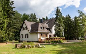 Blick-auf-das-Waldhotel-mit-dem-privaten-Wald-im-Hintergrund-vom-Waldhotel-am-Nuerburgring-in-der-Eifel-in-Baar